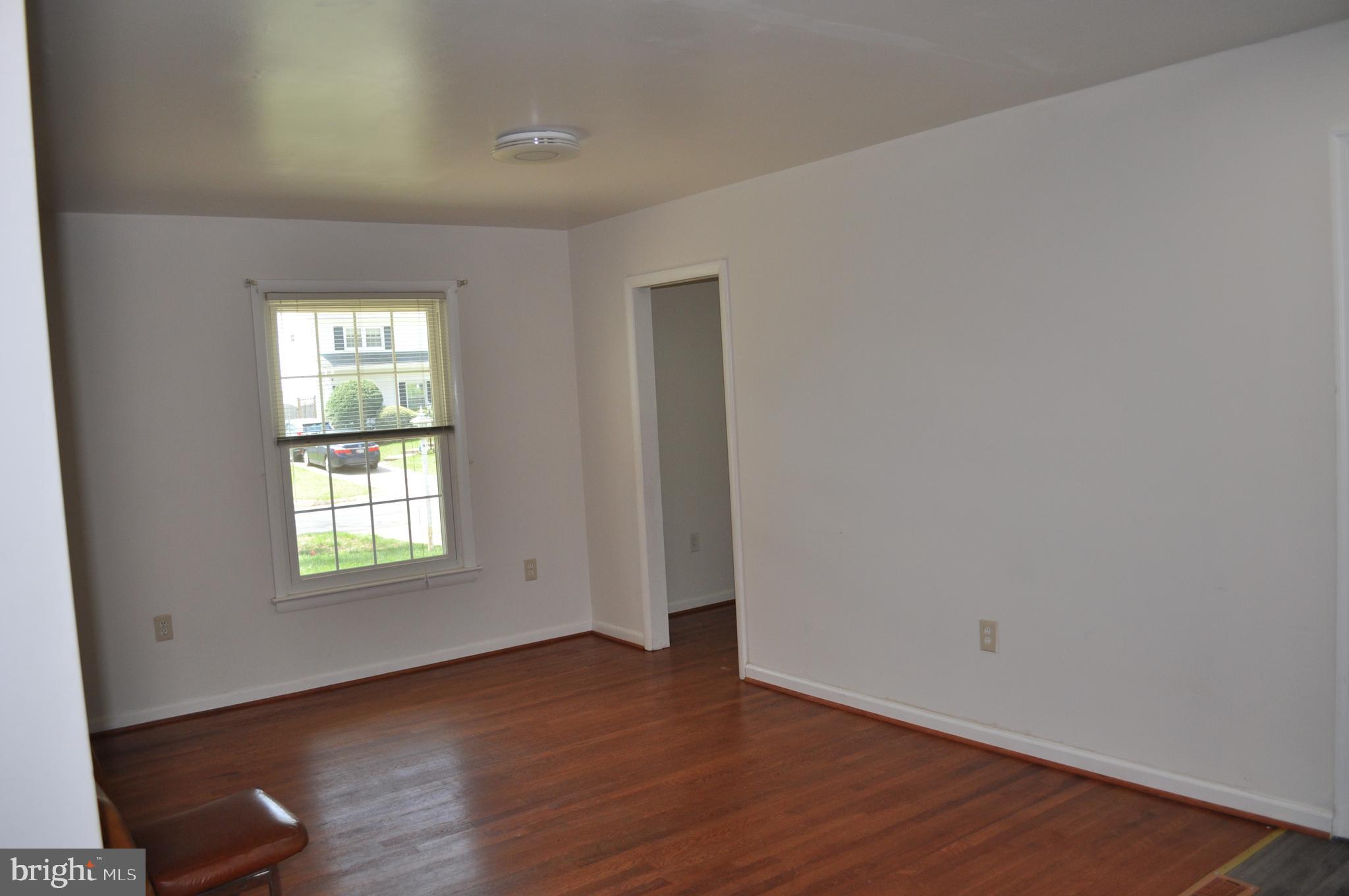 11809 Milbern Drive Potomac, MD 20854 - Photo 6 of 36 an empty room with wooden floor and window