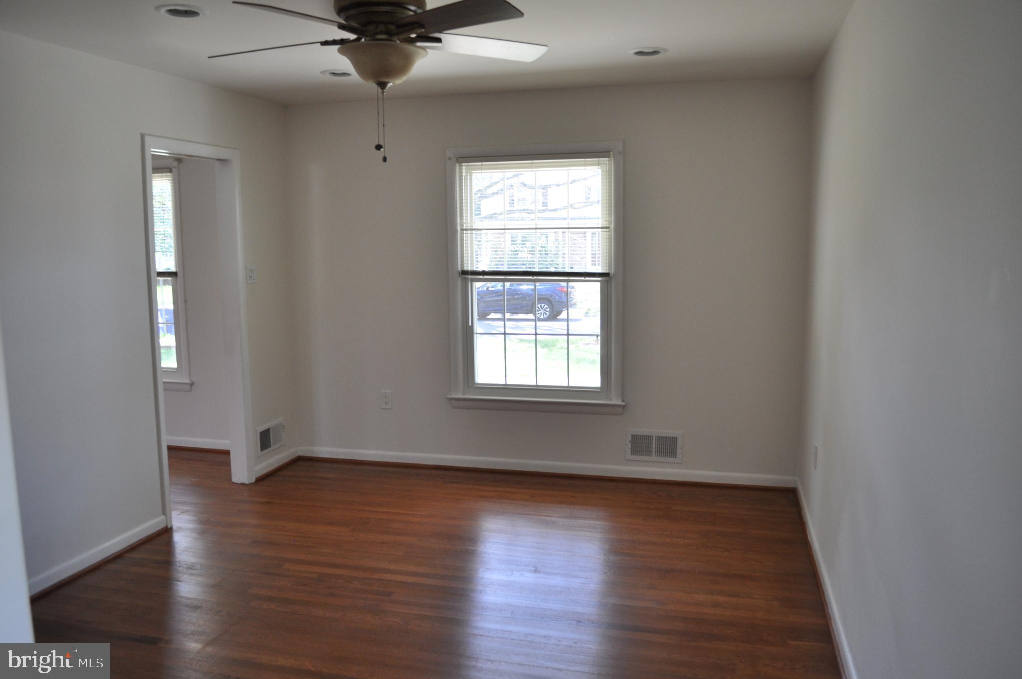 11809 Milbern Drive Potomac, MD 20854 - Photo 7 of 36 a view of an empty room with wooden floor and a window