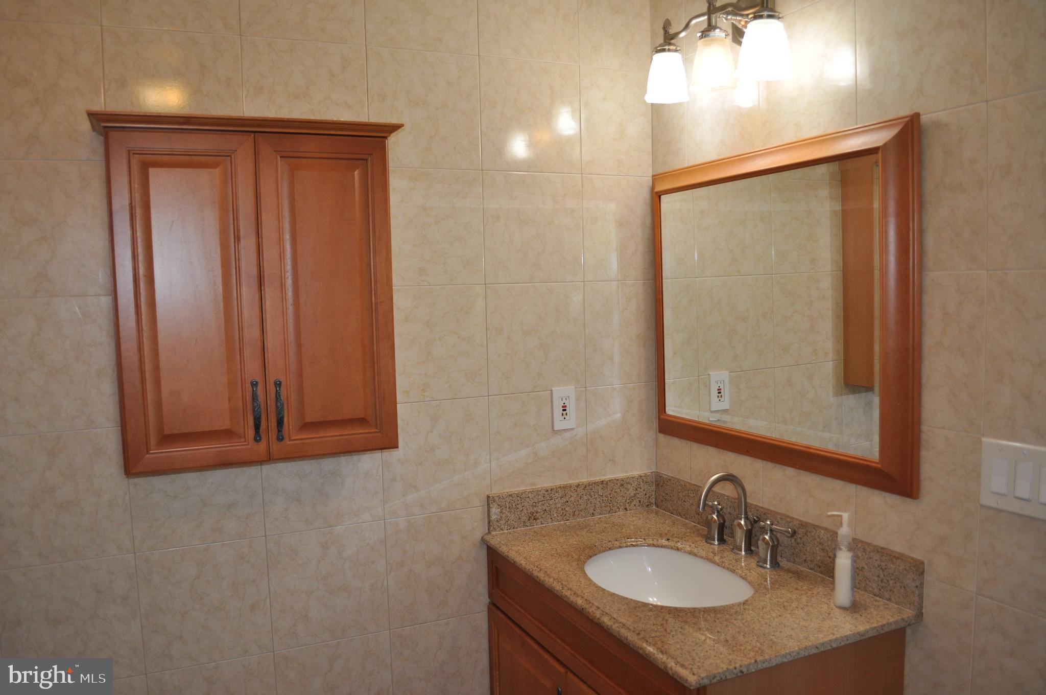 11809 Milbern Drive Potomac, MD 20854 - Photo 9 of 36 a bathroom with a sink vanity and mirror