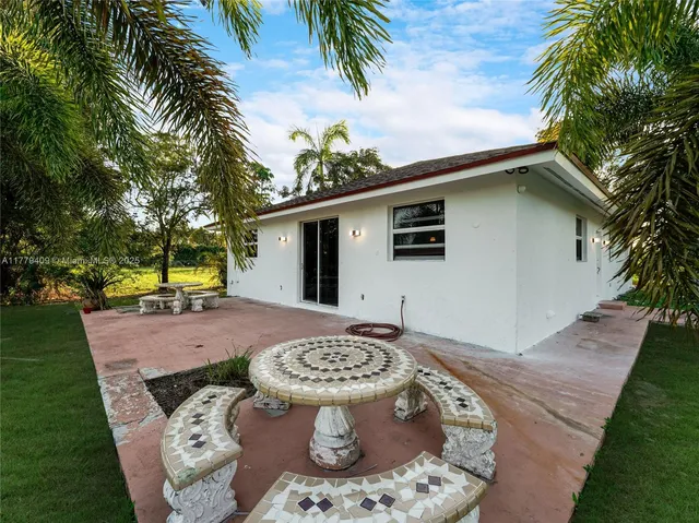 a view of a backyard with a fountain plants and large tree