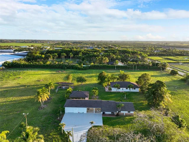 an aerial view of a house with a garden and lake view