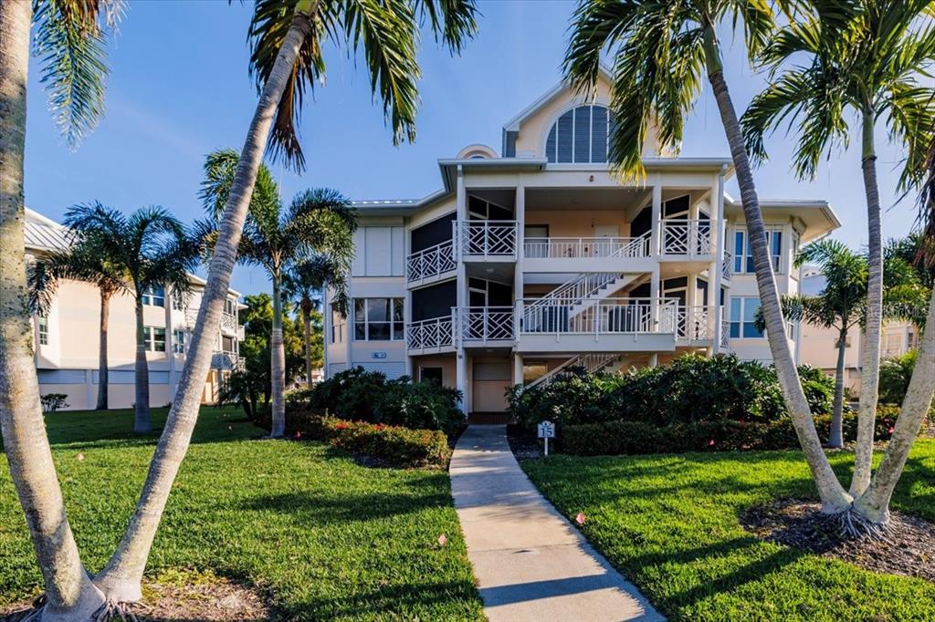 11000 Placida Road, Unit 1501 Placida, FL 33946 - Photo 45 of 46 a front view of multi story residential apartment building with yard and green space