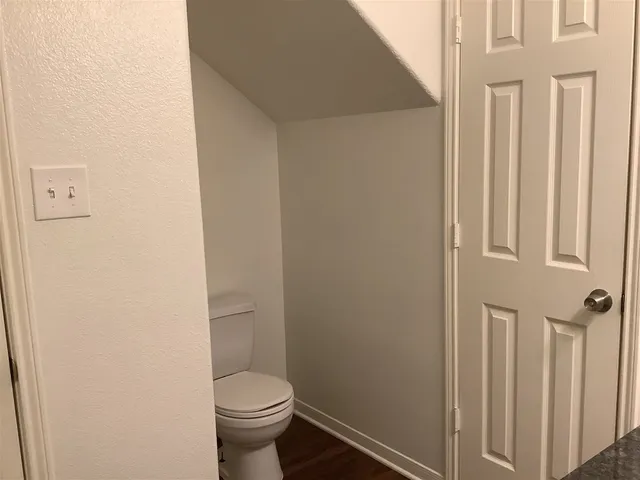 a white toilet sitting next to a small bathroom