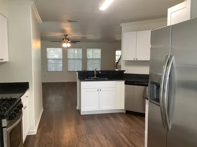 a kitchen with a refrigerator sink and cabinets