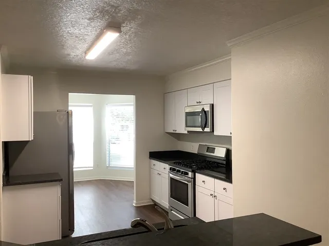a kitchen with a refrigerator and a stove top oven