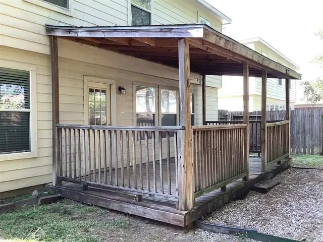 a view of a house with a small yard and a large tree