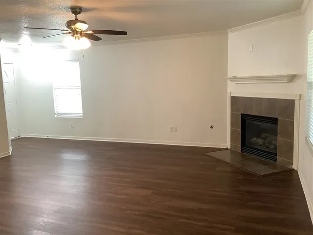 a view of empty room with wooden floor and fireplace