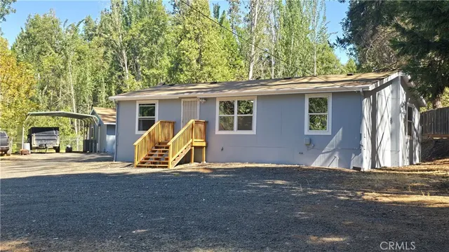a view of a house with backyard and trees