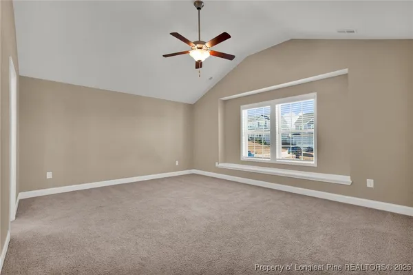 a view of an empty room with a ceiling fan