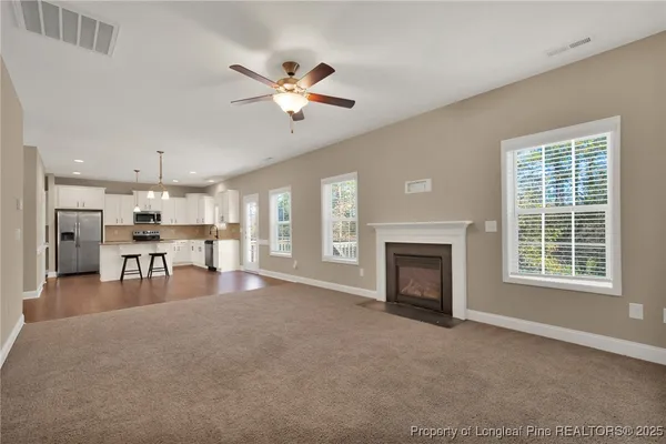 an empty room with windows and fireplace