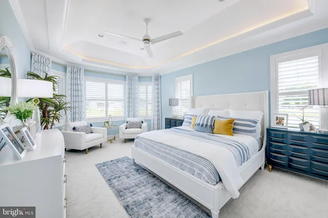 a bedroom with a bed couch and windows