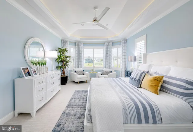 a spacious bedroom with a bed couch and windows