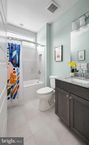 a bathroom with a granite countertop sink a toilet and shower