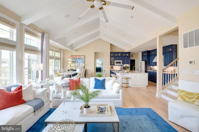 a living room with furniture large window and wooden floor