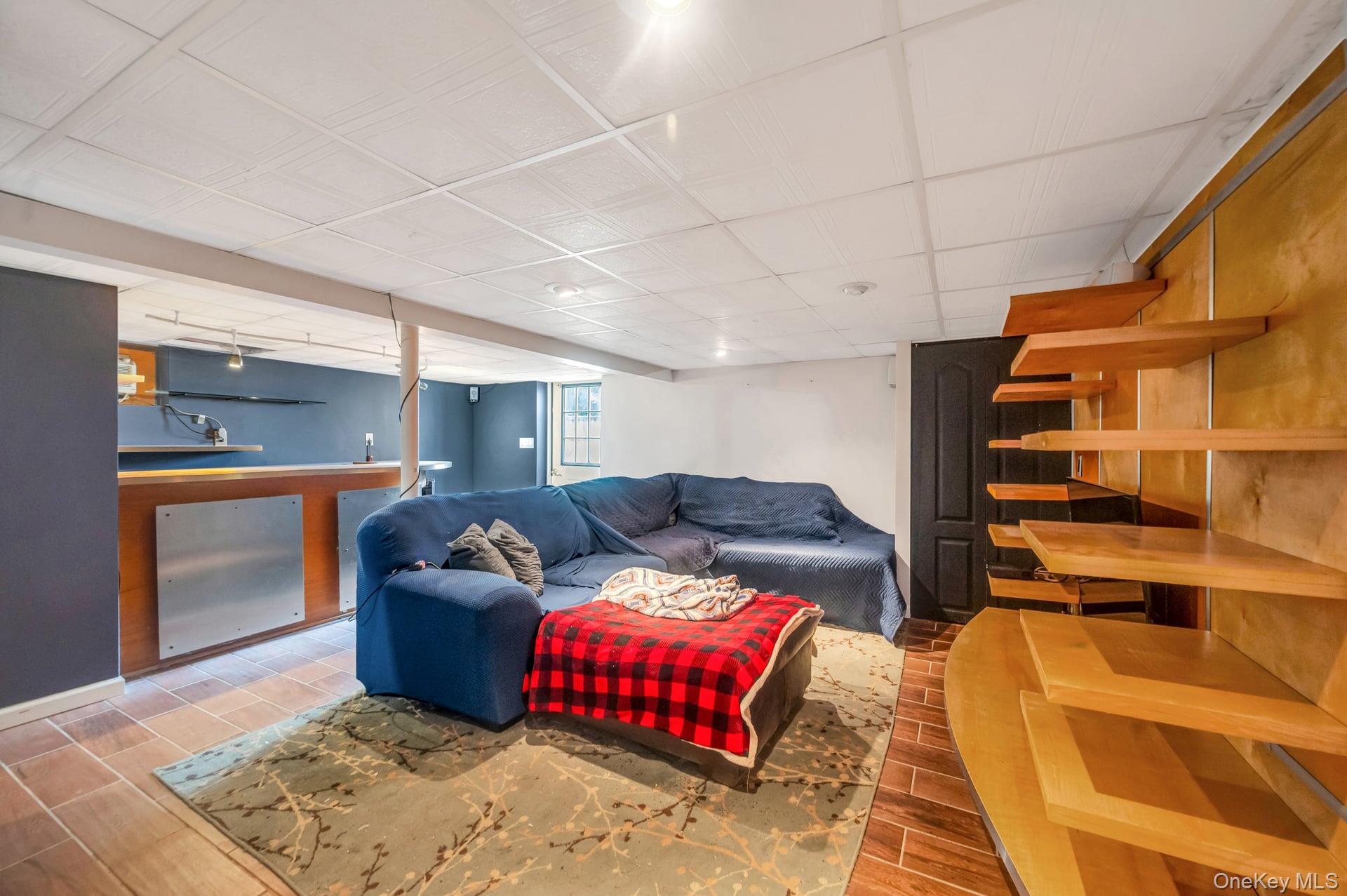8 Brenner Road Coram, NY 11727 - Photo 14 of 18 Living room featuring wood finished floors and bar area