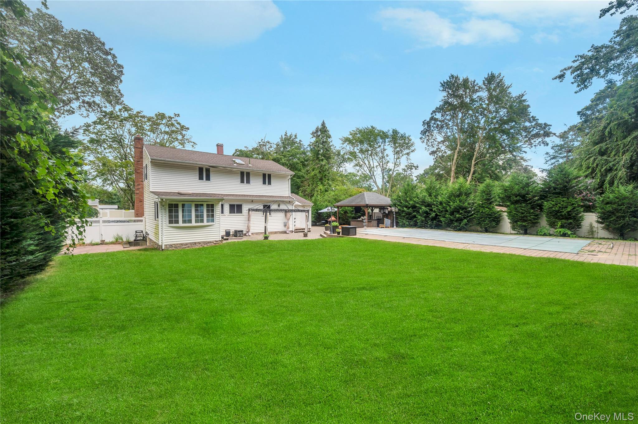 8 Brenner Road Coram, NY 11727 - Photo 17 of 18 Back of property featuring a gazebo, a patio area, and a chimney