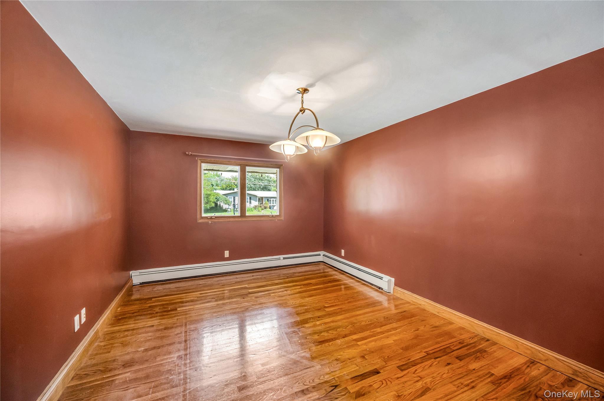 8 Brenner Road Coram, NY 11727 - Photo 9 of 18 Empty room with wood finished floors and baseboard heating