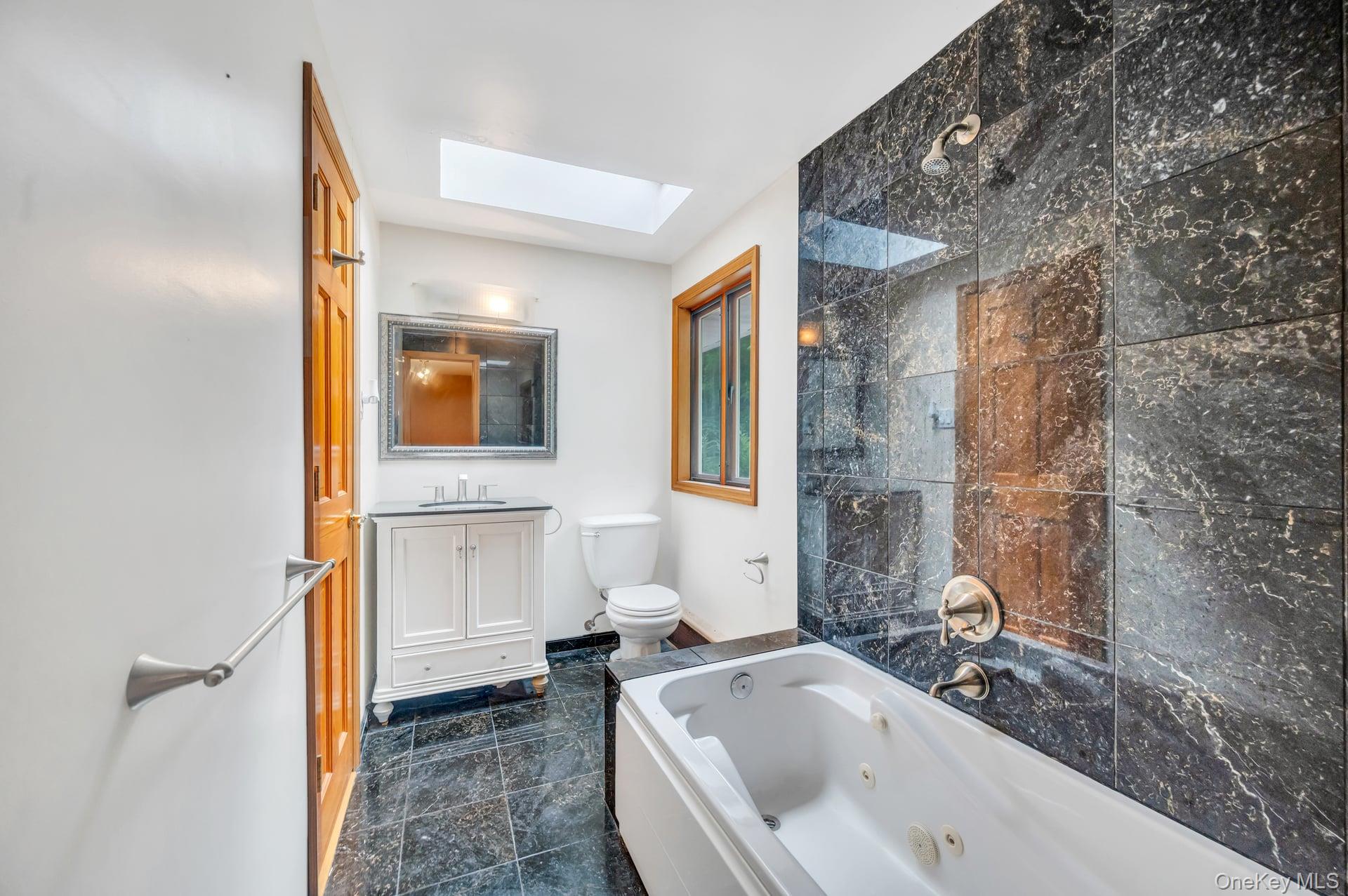 8 Brenner Road Coram, NY 11727 - Photo 10 of 18 Bathroom featuring a skylight and vanity