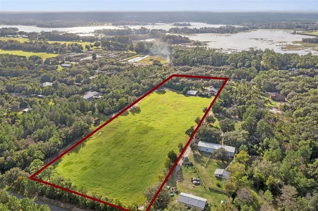 an aerial view of a house with a yard and trees