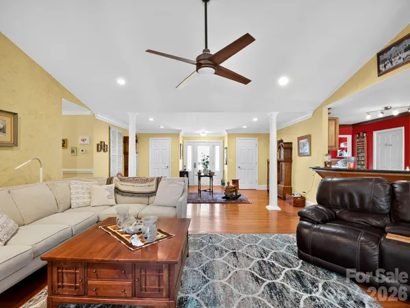 a living room with furniture kitchen view and a large window