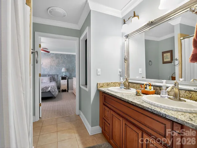 a en suite bathroom with a granite countertop sink and a mirror