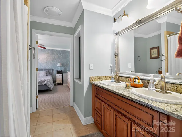 a en suite bathroom with a granite countertop sink and a mirror