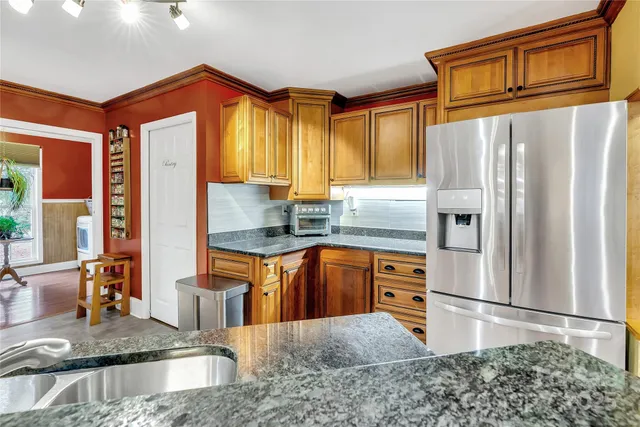 a kitchen with stainless steel appliances granite countertop a refrigerator a stove and a sink