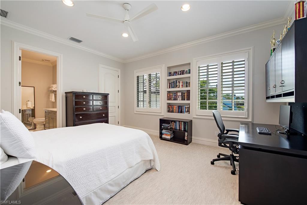 Xxx Lantern Lane Naples, FL 34102 - Photo 12 of 21 a bedroom with a bed a table and a flat screen tv