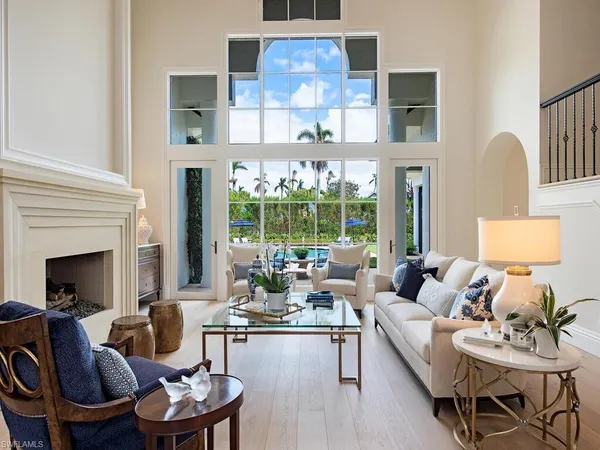 a living room with fireplace furniture and a large window
