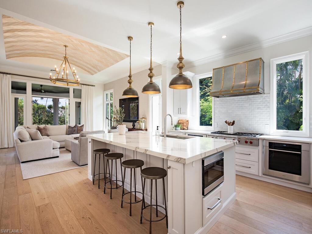 Xxx Lantern Lane Naples, FL 34102 - Photo 3 of 21 a kitchen with stainless steel appliances granite countertop a stove and a view of dining hall with couches