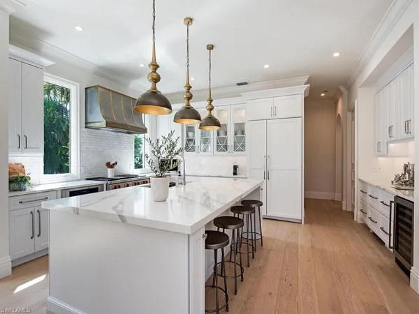 a kitchen with stainless steel appliances kitchen island a large island in the center and wooden floor
