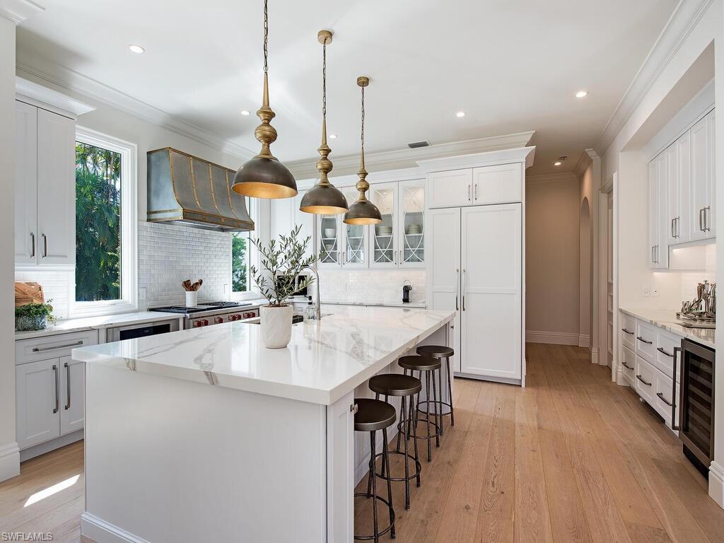 Xxx Lantern Lane Naples, FL 34102 - Photo 4 of 21 a kitchen with stainless steel appliances kitchen island a large island in the center and wooden floor