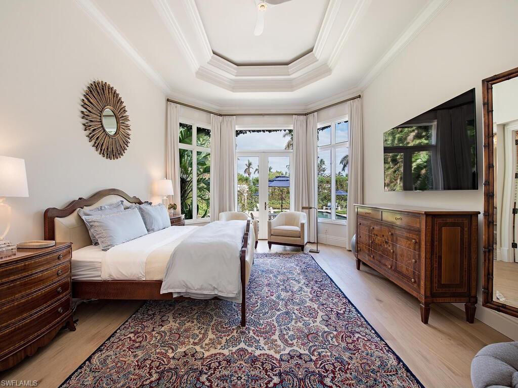 Xxx Lantern Lane Naples, FL 34102 - Photo 7 of 21 a spacious bedroom with a bed a mirror on dresser and a large window