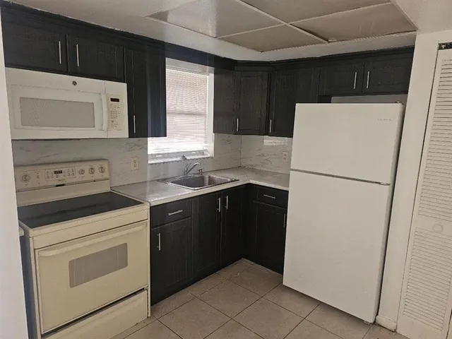 a kitchen with a cabinets sink and white stainless steel appliances