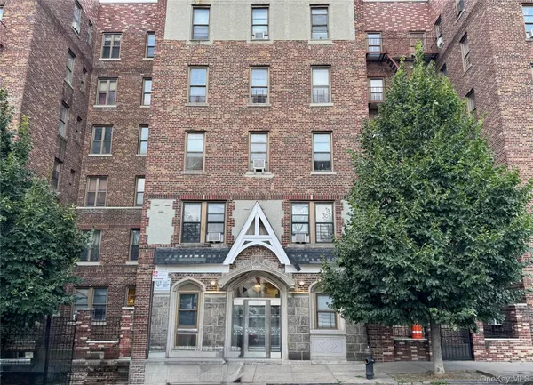 a view of a brick building next to a road with a building
