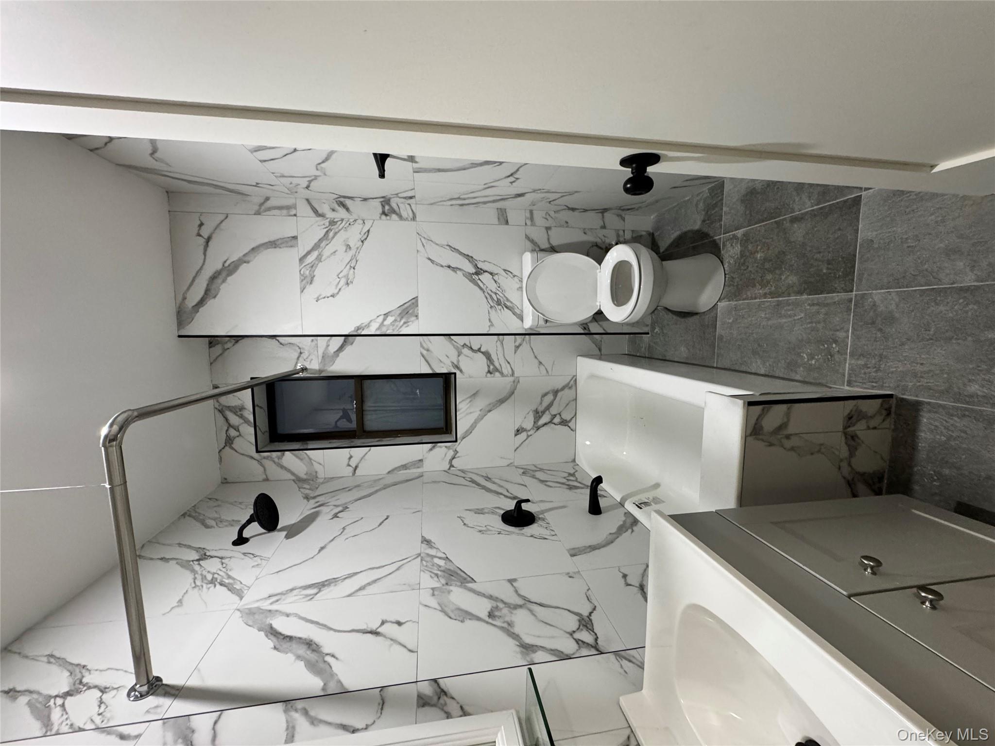 2925 Matthews Avenue, Unit 2H Bronx, NY 10467 - Photo 3 of 6 Full bath featuring tile walls, vanity, and a combined bath / shower with marble appearance