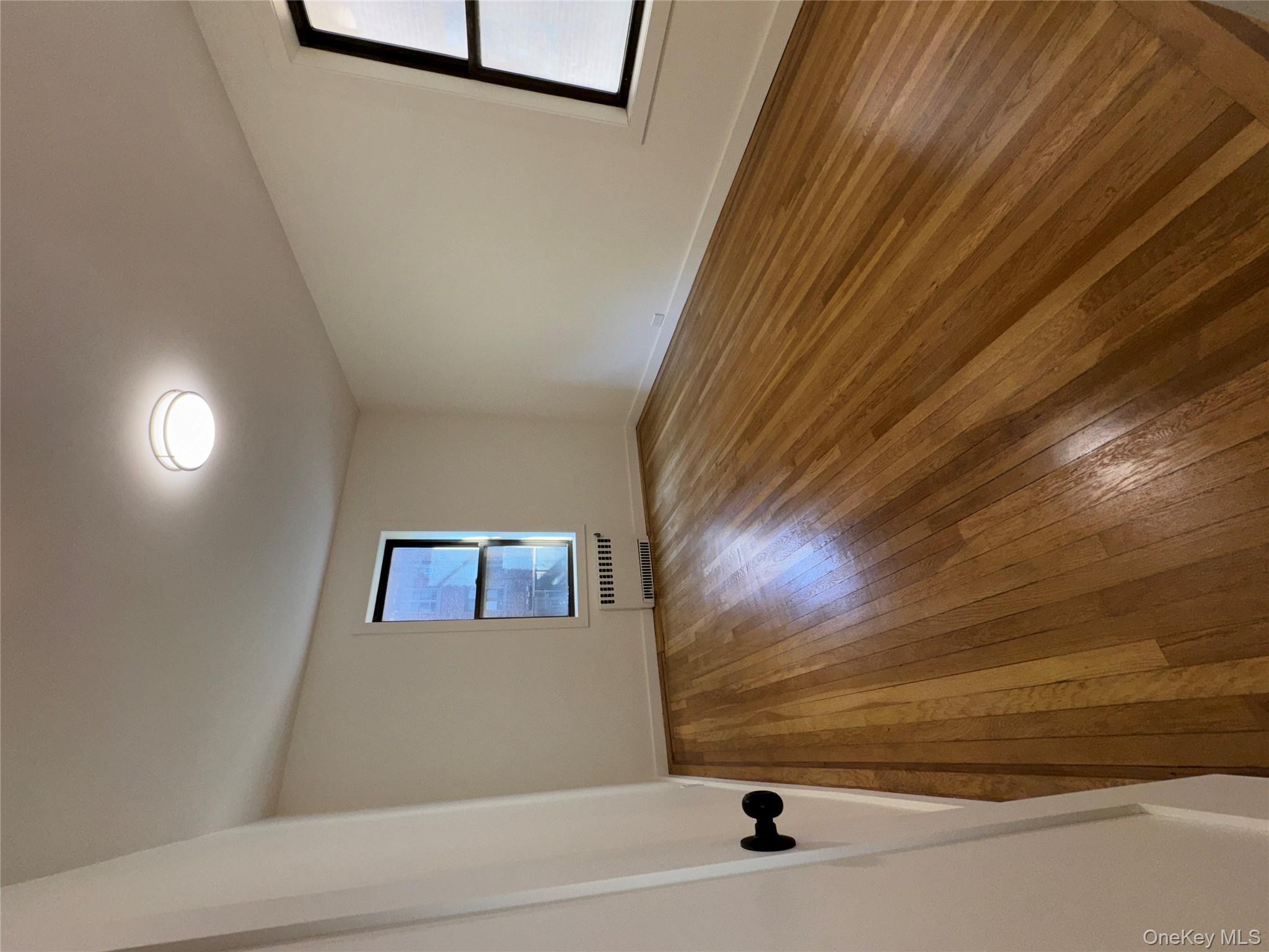 2925 Matthews Avenue, Unit 2H Bronx, NY 10467 - Photo 5 of 6 Empty room with wood-type flooring and radiator heating unit