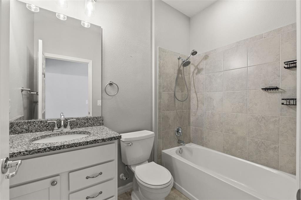12653 Palapa Loop Spring Hill, FL 34610 - Photo 11 of 50 a bathroom with a granite countertop toilet a sink and a bathtub