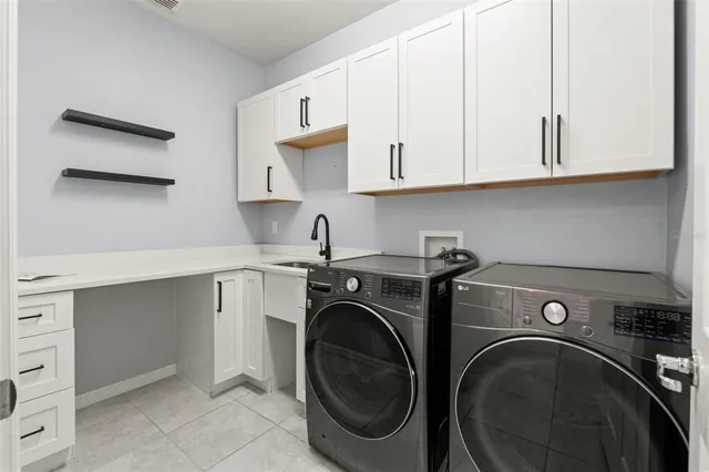 a utility room with sink dryer and washer