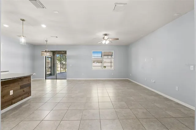 a view of an empty room with a window and fireplace
