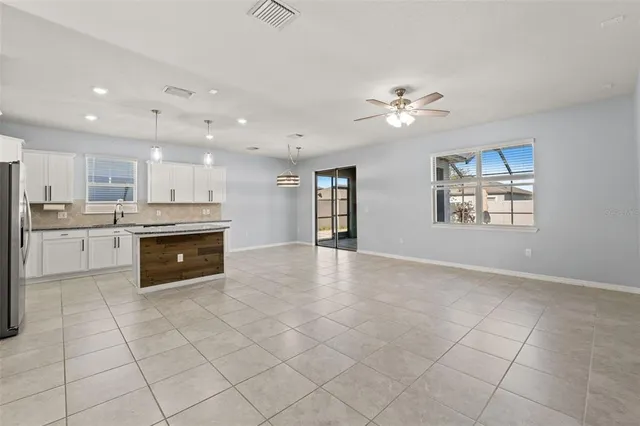 a large kitchen with stainless steel appliances granite countertop a stove top oven a sink dishwasher and a refrigerator