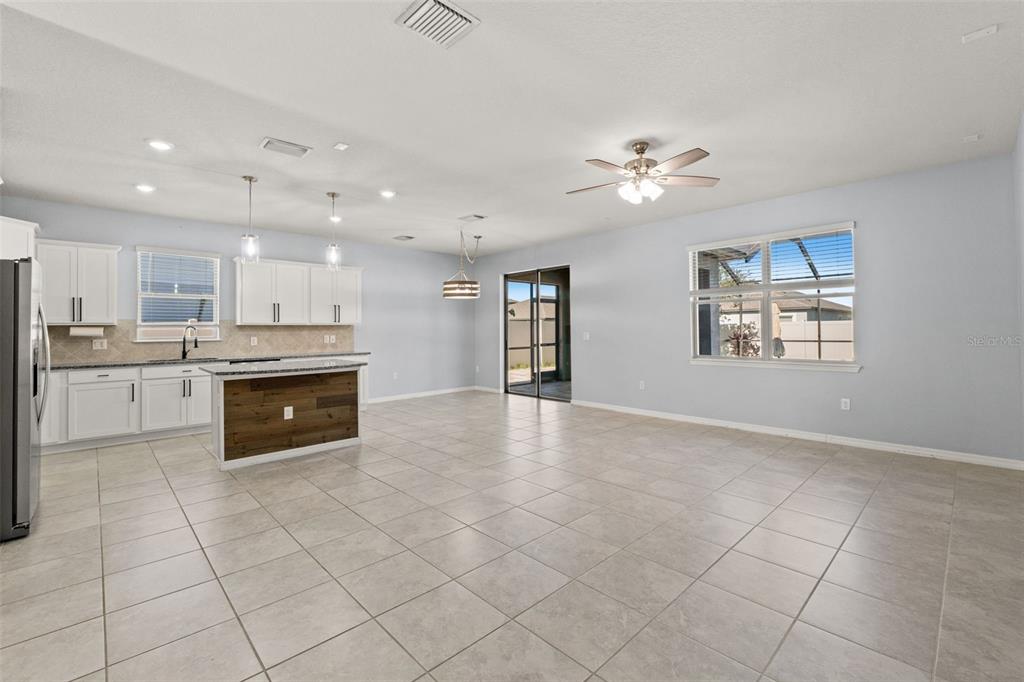 12653 Palapa Loop Spring Hill, FL 34610 - Photo 18 of 50 a large kitchen with stainless steel appliances granite countertop a stove top oven a sink dishwasher and a refrigerator