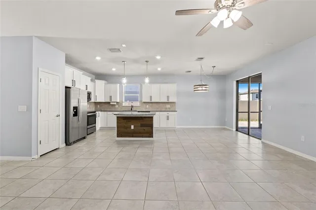 a large white kitchen with a refrigerator a stove a microwave and cabinets