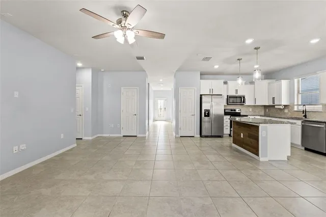 a large kitchen with stainless steel appliances a refrigerator a sink dishwasher with a cabinets and a refrigerator