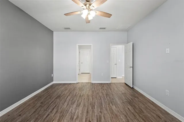 a view of wooden floor and chandelier fan in a room