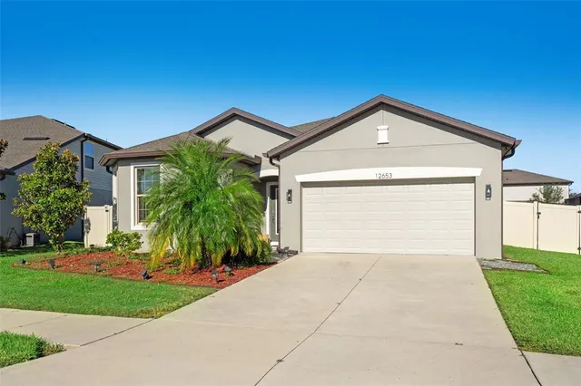 a front view of a house with a yard and garage