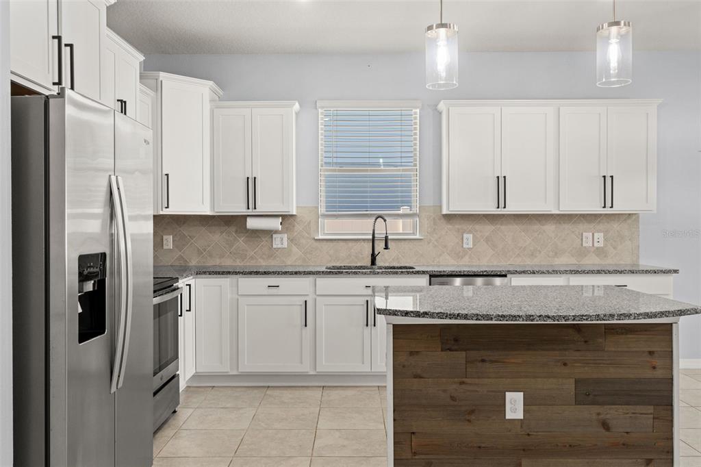 12653 Palapa Loop Spring Hill, FL 34610 - Photo 31 of 50 a kitchen with granite countertop a sink stainless steel appliances and cabinets