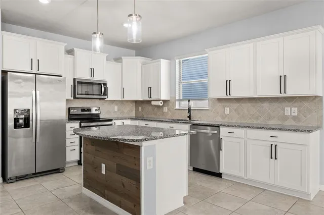 a kitchen with cabinets stainless steel appliances and a counter space
