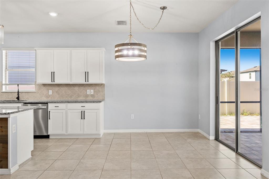 12653 Palapa Loop Spring Hill, FL 34610 - Photo 33 of 50 a kitchen with kitchen island granite countertop cabinets and window