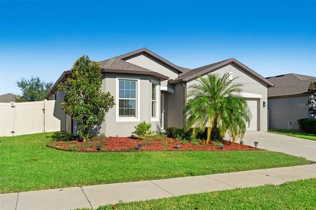 a front view of a house with a garden and plants